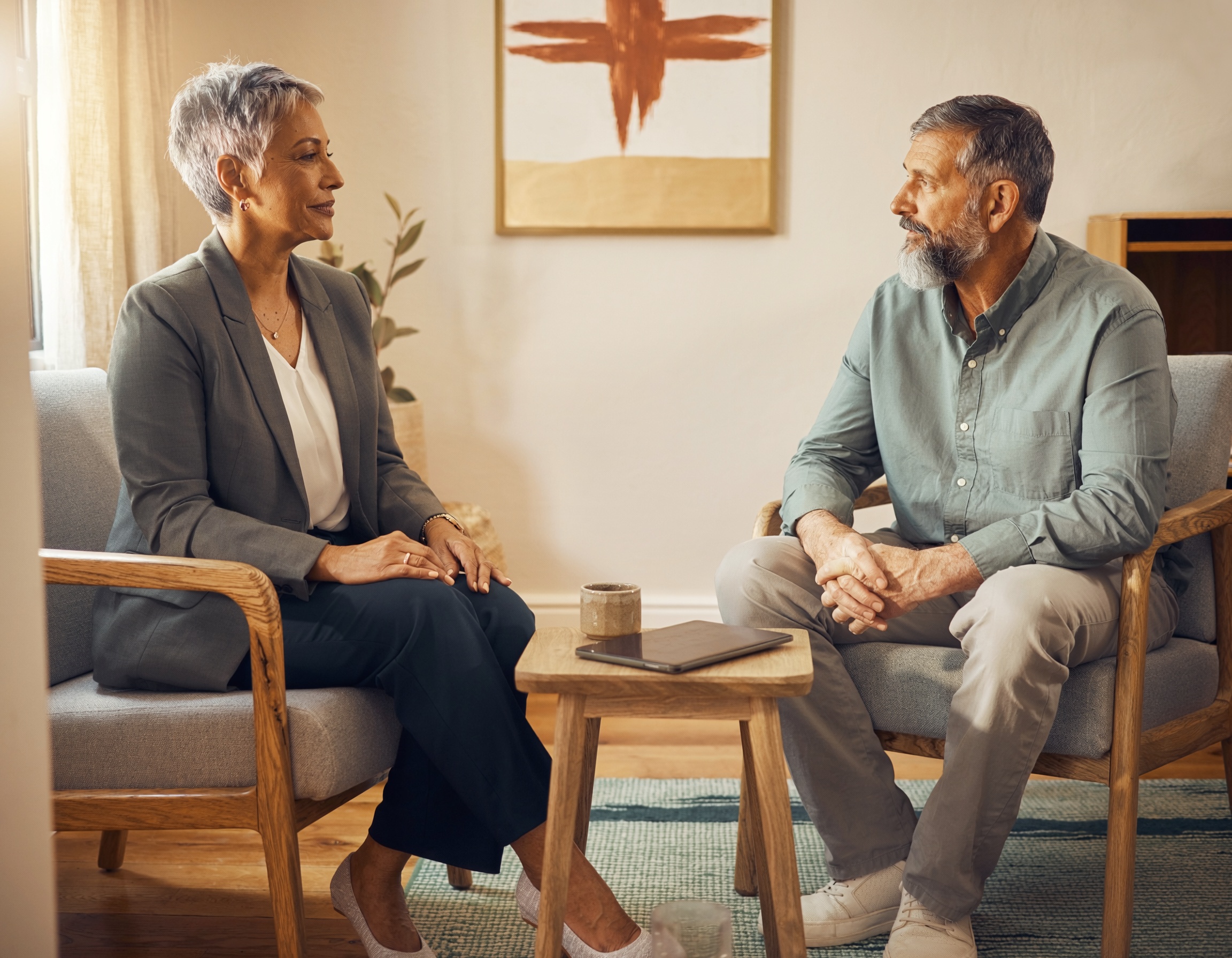 Two adults having a collaborative psychiatric medication-management conversation in a comfortable private office